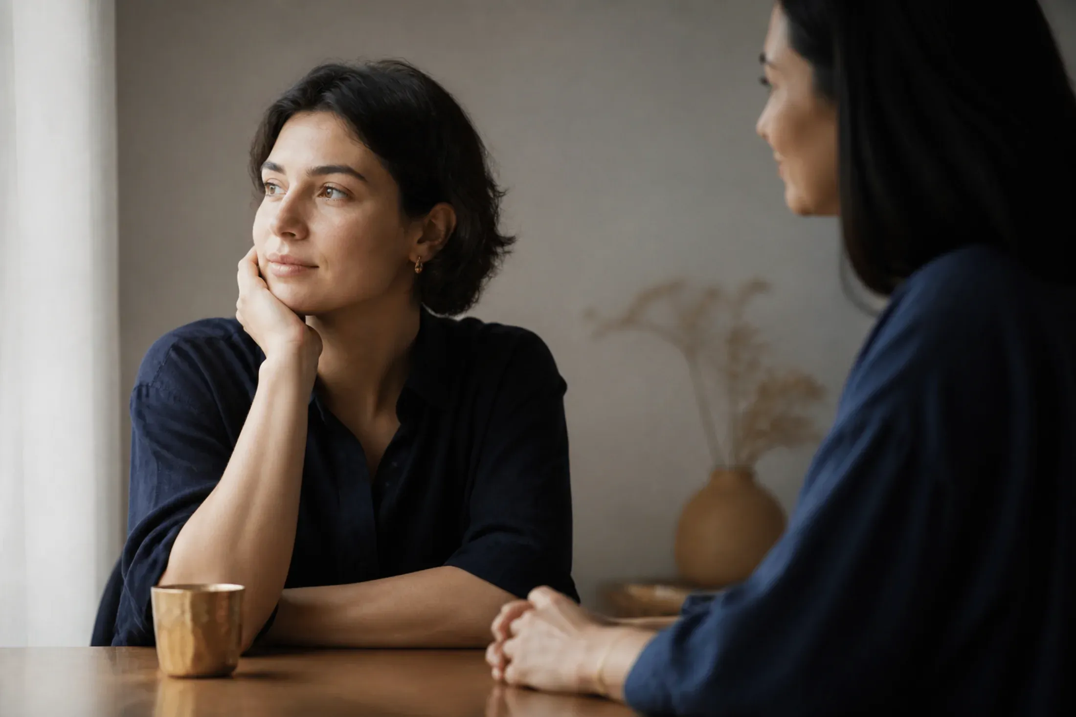 Two adults sharing a thoughtful conversation at a table